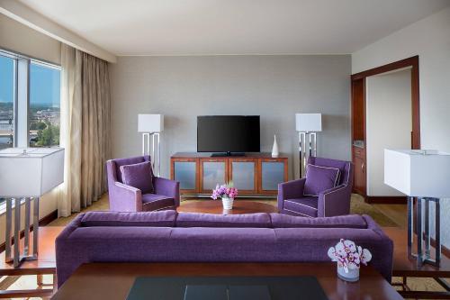 a living room with a purple couch and two purple chairs at JW Marriott Grand Rapids in Grand Rapids