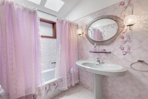 a pink bathroom with a sink and a mirror at Chalet Umbelina con jardin y vista al mar in Palm-mar