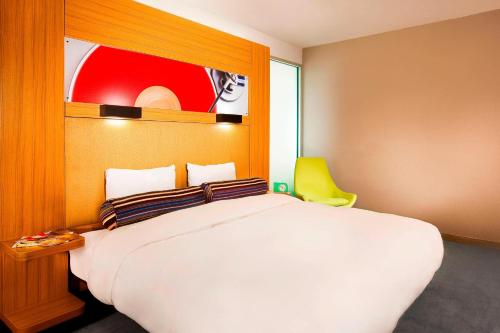 a bedroom with a white bed and a yellow chair at Aloft Mount Laurel in Mount Laurel
