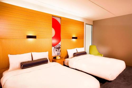 a hotel room with two beds and a painting on the wall at Aloft Mount Laurel in Mount Laurel