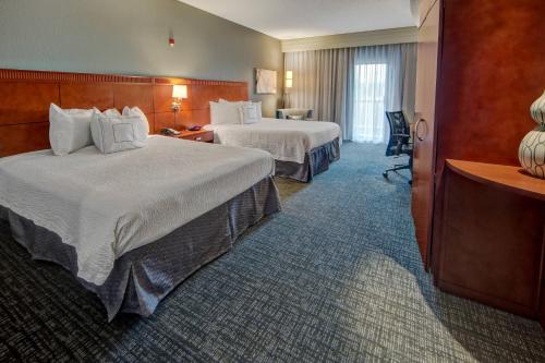 サウスヘイブンにあるCourtyard by Marriott Memphis Southavenのベッド2台とデスクが備わるホテルルームです。