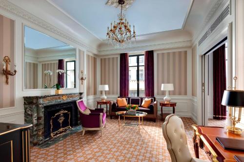 a living room with a fireplace and a chandelier at The St. Regis New York in New York