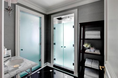 a bathroom with a sink and a glass shower at The St. Regis New York in New York