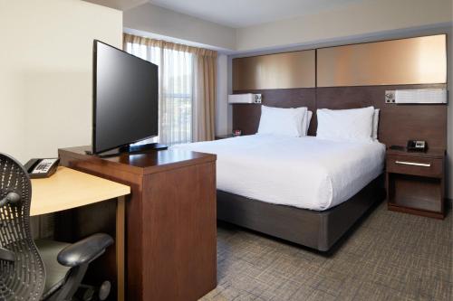 um quarto de hotel com uma cama e uma secretária com uma televisão em Residence Inn San Diego Carlsbad em Carlsbad