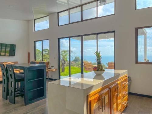 a kitchen with a counter and a table and some windows at Canavida Villas & Resort in Uvita