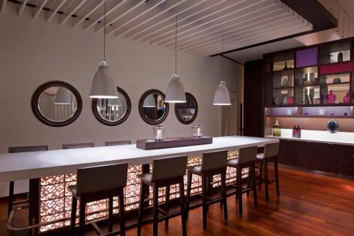a kitchen with a bar with chairs and mirrors at Le Méridien Nouméa Resort & Spa in Noumea