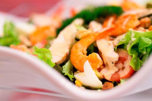 a salad with cheese and vegetables in a white bowl at Le Méridien Nouméa Resort & Spa in Noumea