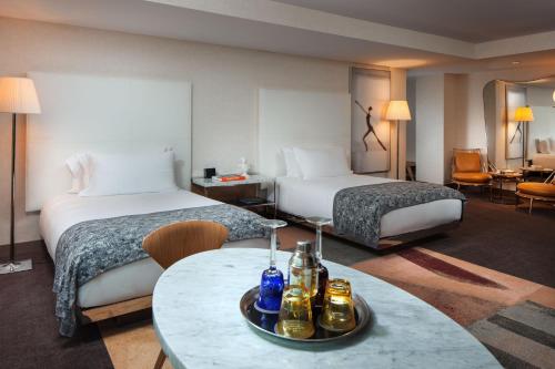 a hotel room with two beds and a table with drinks on it at SLS Hotel, a Luxury Collection Hotel, Beverly Hills in Los Angeles