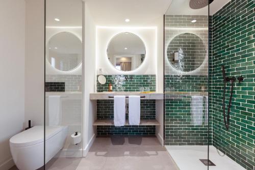 a bathroom with a shower and a toilet and two mirrors at Samaritana Suites in Palma de Mallorca