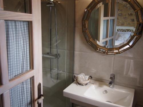 a bathroom with a sink and a mirror and a shower at El Rincón de Escalante in Escalante