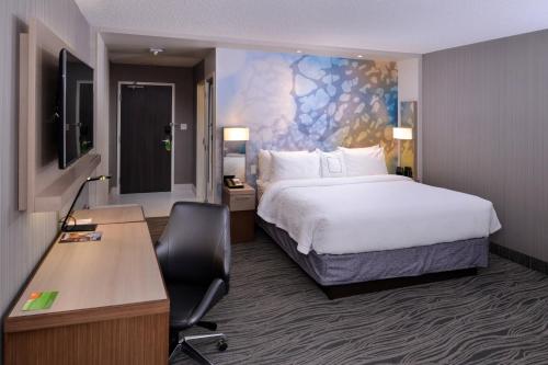 Habitación de hotel con cama y escritorio en Courtyard by Marriott Saskatoon Airport en Saskatoon