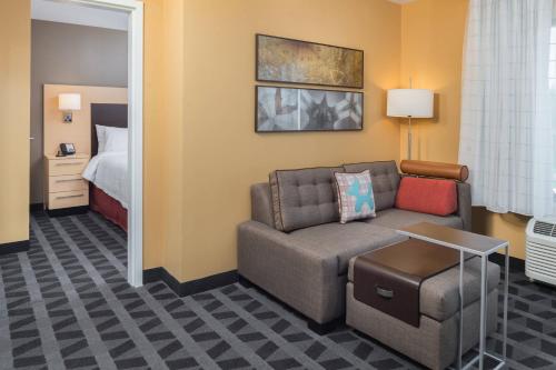 a living room with a couch and a bed at TownePlace Suites by Marriott New Hartford in New Hartford