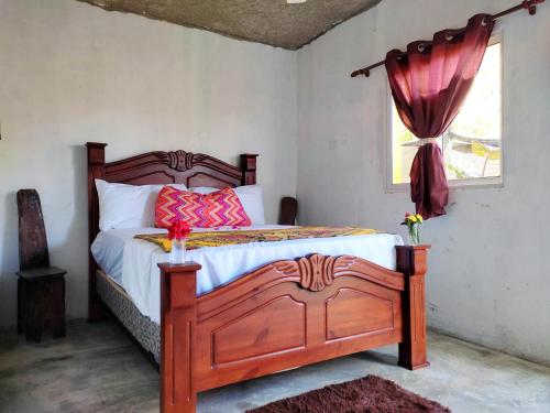 a bedroom with a wooden bed with a window at Hotel i t a in Las Galeras