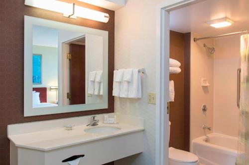 a bathroom with a sink and a mirror and a toilet at SpringHill Suites by Marriott Peoria in Peoria