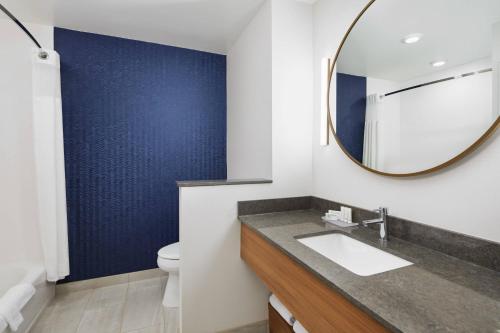 a bathroom with a sink and a mirror at Fairfield Inn & Suites by Marriott Raleigh Wake Forest in Wake Forest