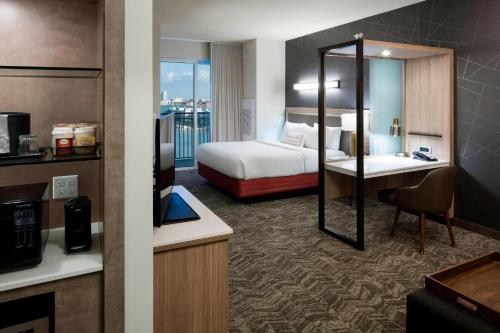 a hotel room with a bedroom with a bed and a desk at SpringHill Suites by Marriott Clearwater Beach in Clearwater Beach