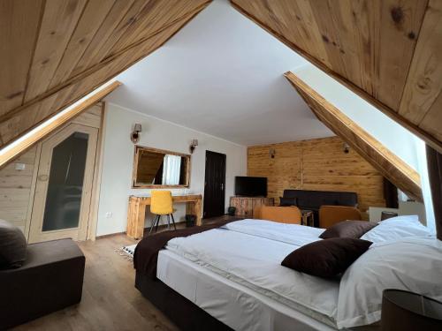 a bedroom with a large bed in a room with wooden ceilings at Nicole Hotel & Restaurant in Samokov