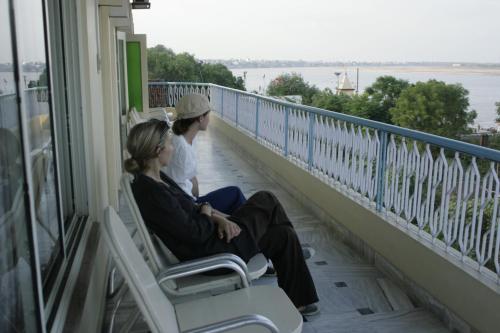 two women sitting on a balcony looking out at the water at Hotel Temple On Ganges in Varanasi
