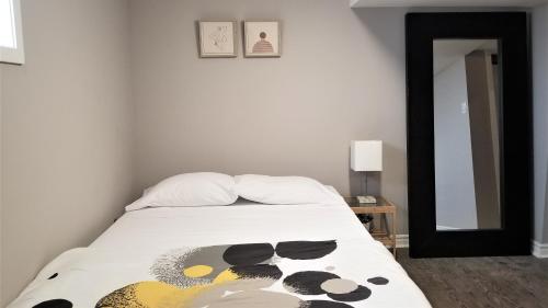 1 dormitorio con cama y espejo en Charming Studio with Parking, Netflix, Full Kitchen - Close to Algonquin College, en Ottawa