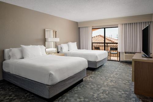 um quarto de hotel com duas camas e uma televisão em Courtyard by Marriott Key West Waterfront em Key West