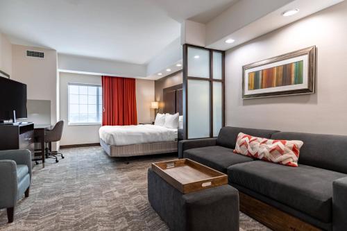 sala de estar con sofá y cama en una habitación en SpringHill Suites by Marriott Waco Woodway, en Woodway