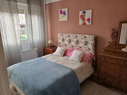 um quarto com uma cama, uma cómoda e uma janela em Casa Oviedo centro em Oviedo