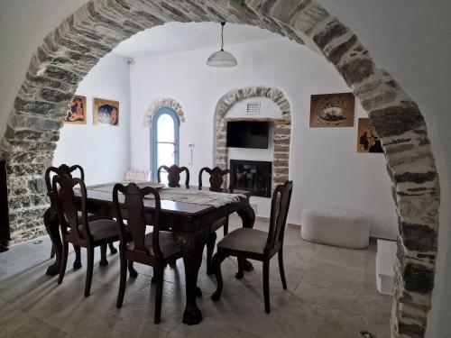 a dining room with a table and chairs at PYRGOS - Traditional house at Kaloxilos, Naxos in Khalkíon