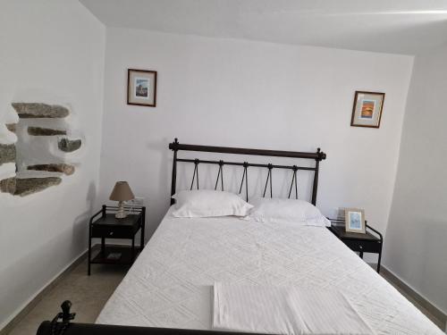 a bedroom with a large bed with two night stands at PYRGOS - Traditional house at Kaloxilos, Naxos in Khalkíon