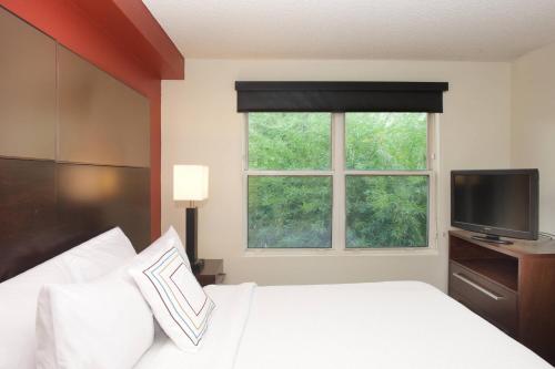 a bedroom with a white bed and a window at Residence Inn Phoenix Mesa in Mesa