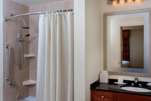 a bathroom with a shower curtain and a sink at Residence Inn by Marriott New York Manhattan/Times Square in New York