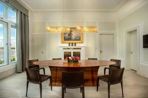 a dining room with a wooden table and chairs at Hotel Atlantic Hamburg, Autograph Collection in Hamburg