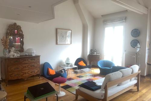 sala de estar con sofá, sillas y mesa en Duplex of 90m near Montmartre, en París