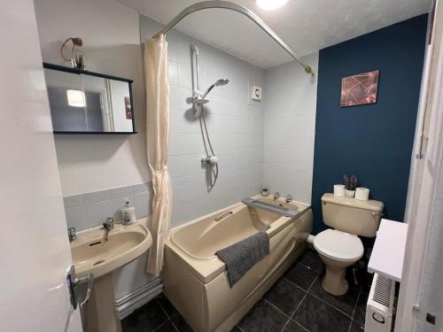 a bathroom with a tub and a sink and a toilet at Spacious Apartment with Parking in Norwich