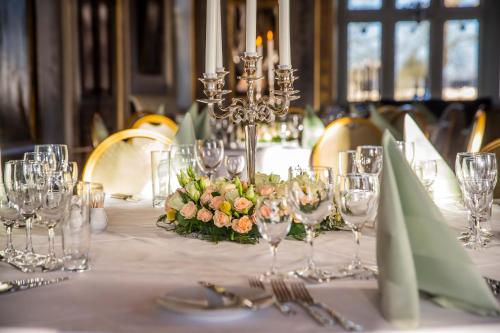 a table with wine glasses and flowers on it at Fuglsang Herregaard Hotel in Nykøbing Falster