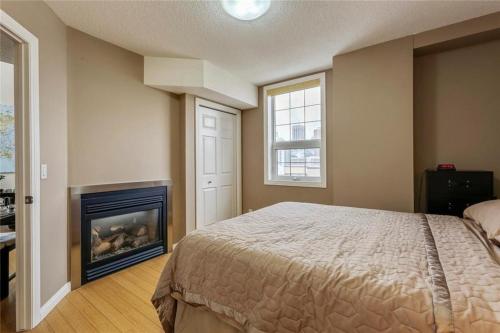 1 dormitorio con 1 cama y chimenea en Stampede Park en Calgary