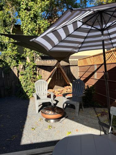 a patio with two chairs and a grill and an umbrella at Citrus Studio A in Chico