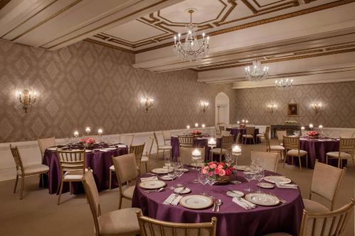 a banquet room with purple tables and chairs and chandeliers at The St. Regis Washington, D.C. in Washington