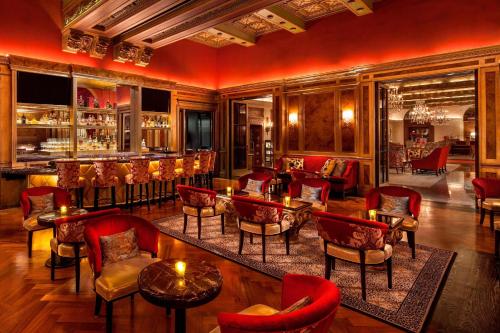 a restaurant with red chairs and tables and a bar at The St. Regis Washington, D.C. in Washington