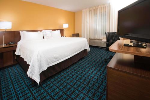 Fairfield Inn & Suites Idaho Falls في ايداهو فولز: غرفة فندقية بسرير وتلفزيون بشاشة مسطحة