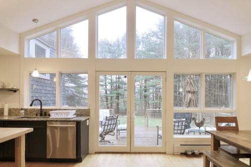 uma cozinha com portas de vidro deslizantes e uma cozinha com um pátio em Woodland Hills Modern Cottage Minutes from Downtown Great Barrington em Great Barrington