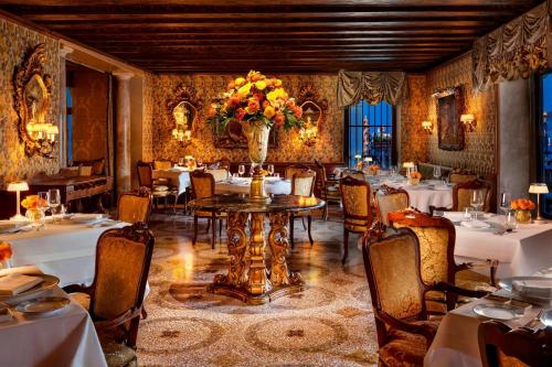 a restaurant with tables and chairs and a vase of flowers at The Gritti Palace, a Luxury Collection Hotel, Venice in Venice