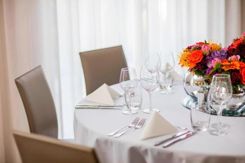 a table with wine glasses and a vase of flowers at AC Hotel by Marriott Manchester Salford Quays in Manchester