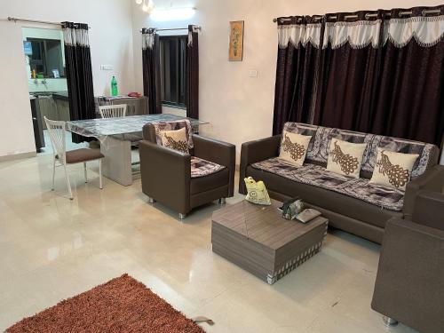 a living room with two couches and a table at Samruddhi farms rooms S1 near mihan in Nagpur