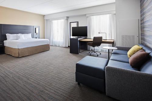 a hotel room with a bed and a couch at Residence Inn by Marriott Knoxville Downtown in Knoxville
