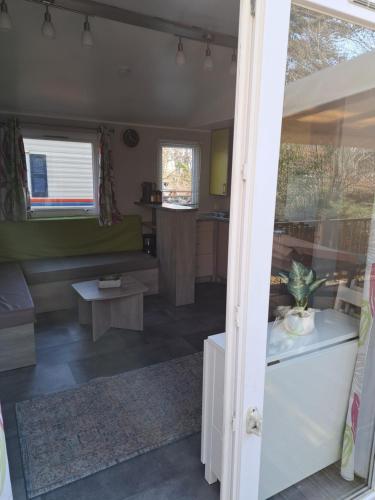 Saint-Chéron的住宿－Mobil home confort 6 personnes，一间客厅和厨房,位于一个小房子里