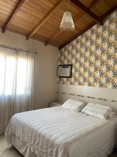 um quarto com uma cama grande e uma colcha branca em Rio Grande Beach House em Rio Grande