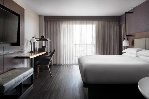 a hotel room with a bed and a desk and a television at Visalia Marriott at the Convention Center in Visalia