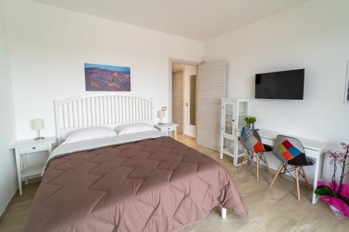 a bedroom with a large bed and a flat screen tv at Nni Mia in Modica