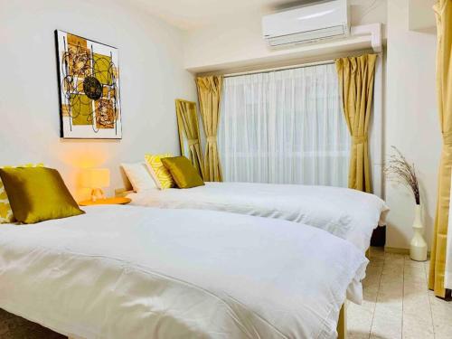 a bedroom with two white beds and a window at Asakusa 2 Bedroom Apartment 西浅草2LDK広々ファミリーorグループ in Tokyo