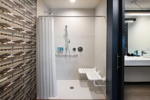 a bathroom with a shower and a sink at Aloft Dallas Euless in Euless